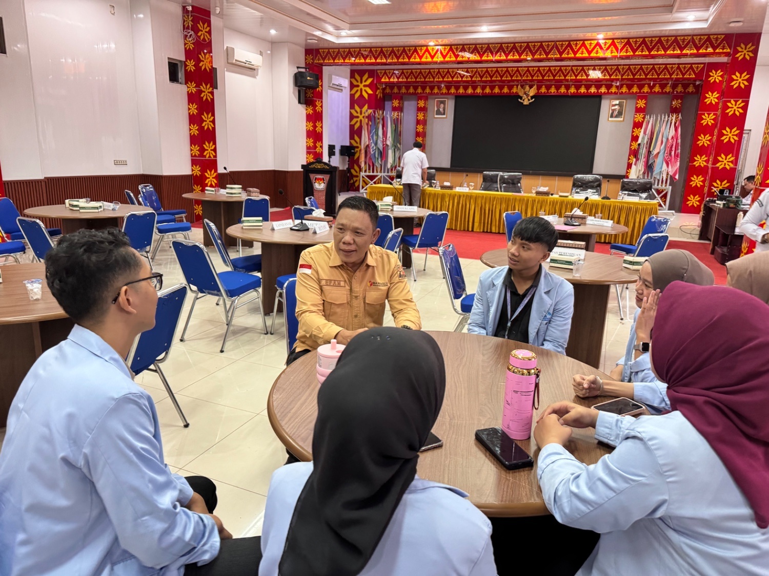 Koordinator Divisi Penanganan Pelanggaran, Data dan Informasi (PPDatin) Bawaslu Kota Palembang Efan Yutawan berbincang dengan mahasiswa usai mengikuti Forum Konsultasi Publik (FKP) Pemutakhiran Data Pemilih Berkelanjutan (PDPB) yang diselenggarakan KPU Kota Palembang di Aula Demokrasi KPU Kota Palembang, Kamis (23/07/2026). Diskusi tersebut membahas pentingnya partisipasi generasi muda dalam membangun literasi kepemiluan dan menjaga kualitas data pemilih. (Foto: Humas Bawaslu Kota Palembang).